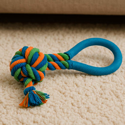 Colorful dog rope toy with a handle on a beige carpet
